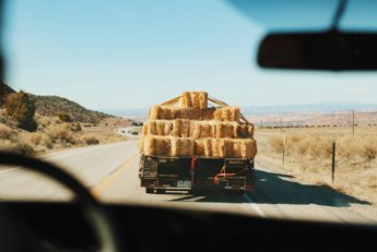 Dreaming to hitchhike a truck full of hay stacks
