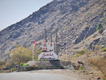 13 welcome to Madha Oman sign Sultan Qaboos Madha and Nahwa border exclave Oman UAE