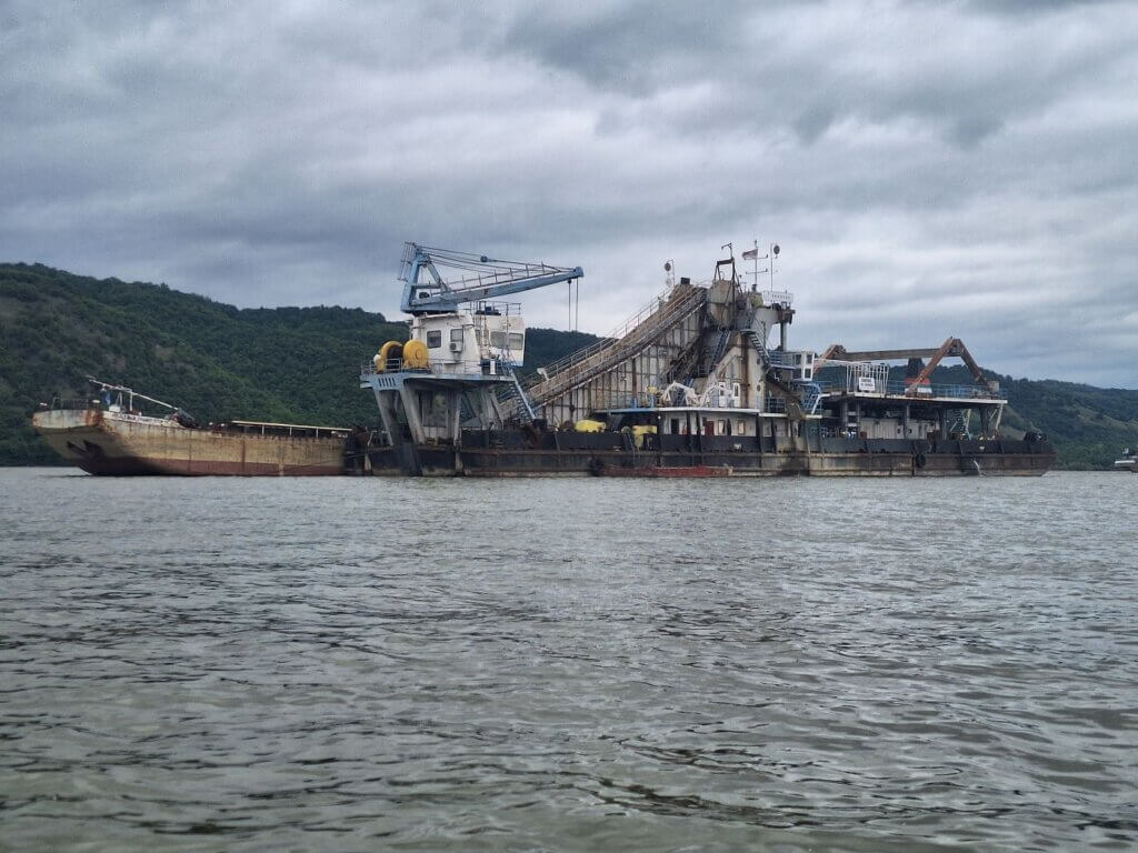 Danube riverbed sediment mining dredging aggregate machine loud grinding noises Serbia Romania