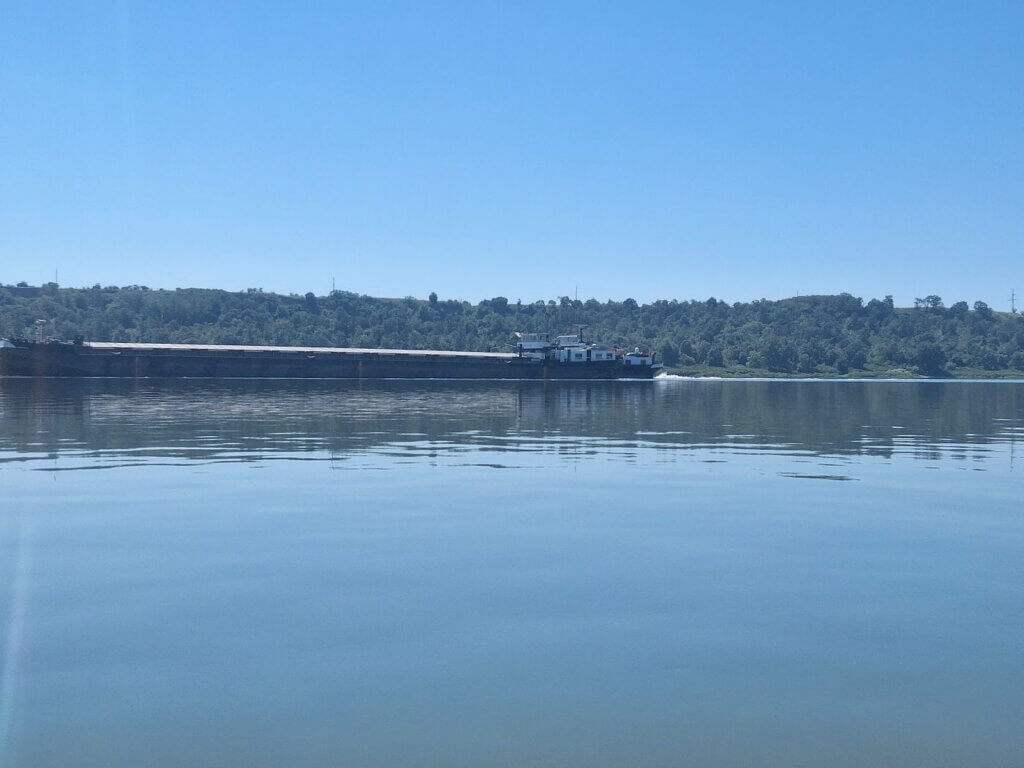cargo ship traveling upstream Danube River near Iron Gate II dam Serbia Romania