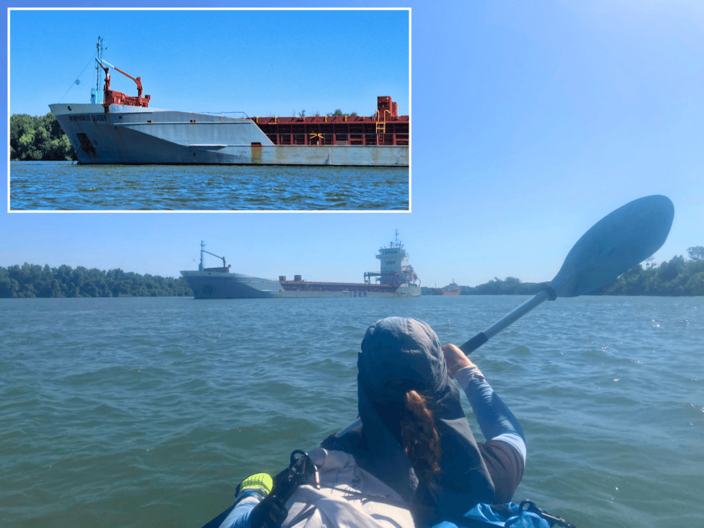 Iris Veldwijk kayaking past the Bosphorus Queen vessel Danube Delta river anchorage Romania Ukraine border area