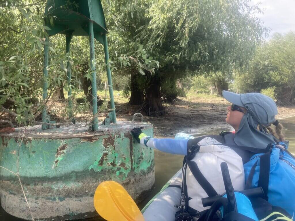 Iris Veldwijk touching green buoy Danube River Romania floating lost stranded