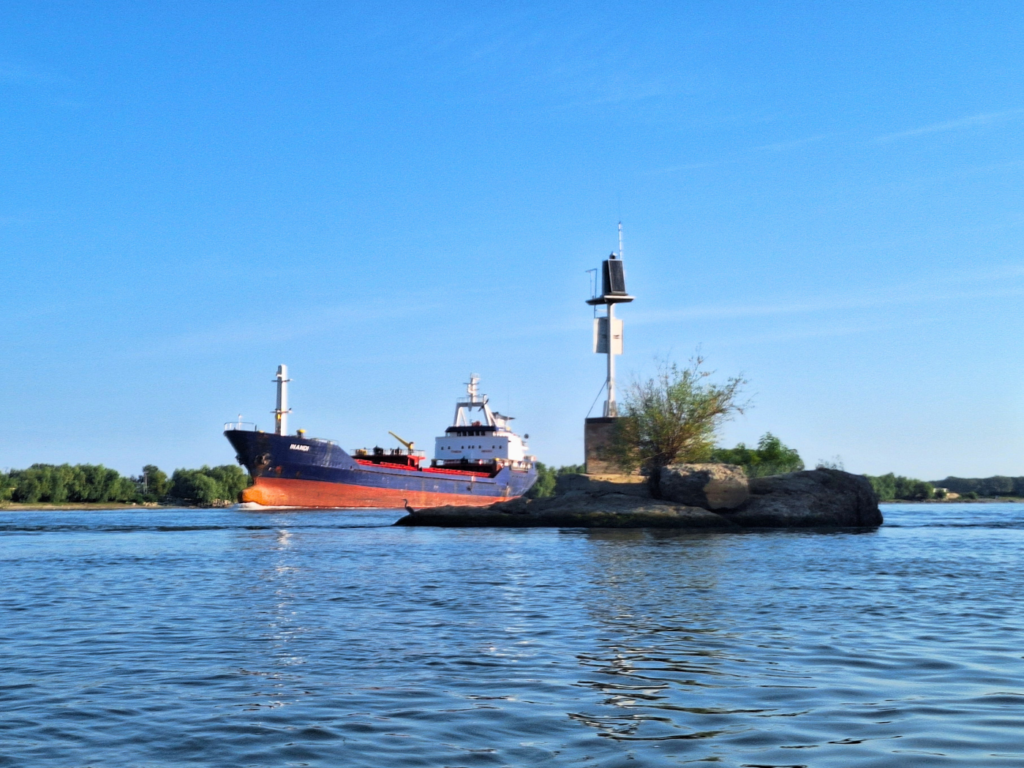oil tanker rock in the riverbed danger shipping lane Danube Delta River Tulcea Branch warning buoy fixed on land