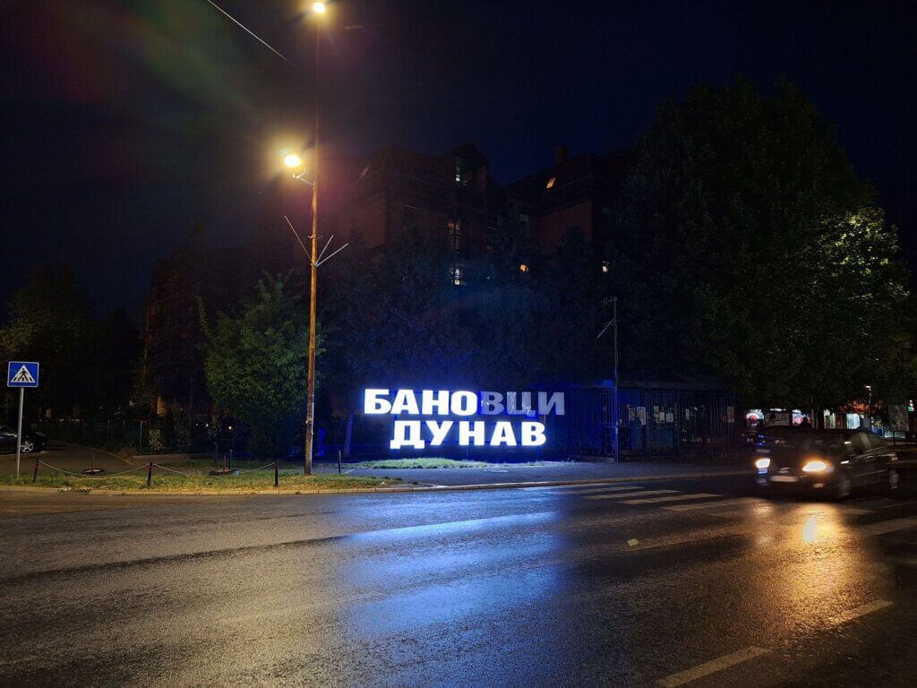 Novi Banovci Dunav Serbia welcome sign at night rain broken light