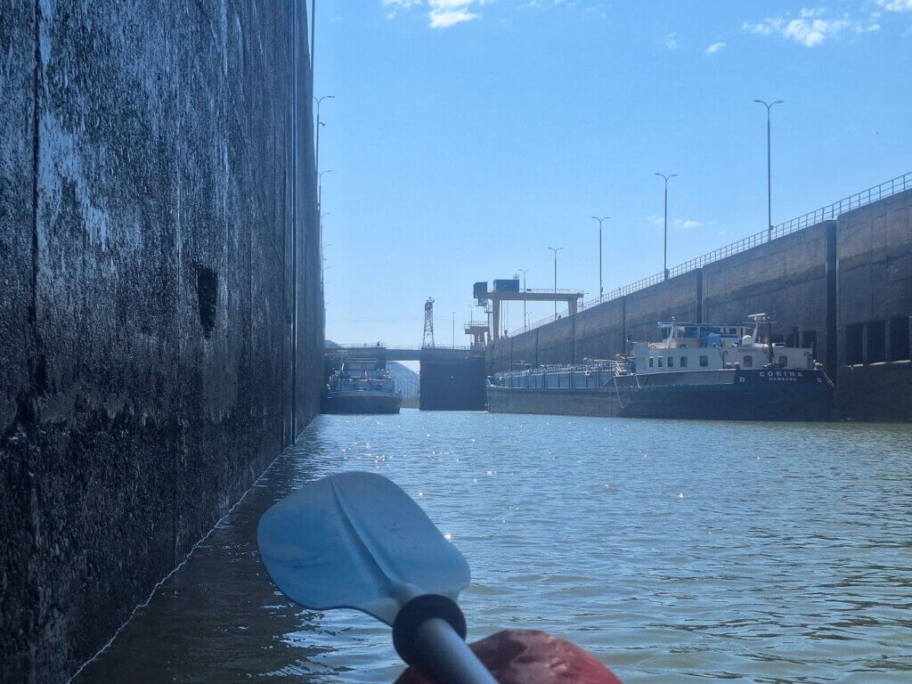 Iron Gate I dam sluice Derdap I Portile de Fier I shipping canal Danube River Romania Serbia lock gate opening Serbian cargo ship sailing through