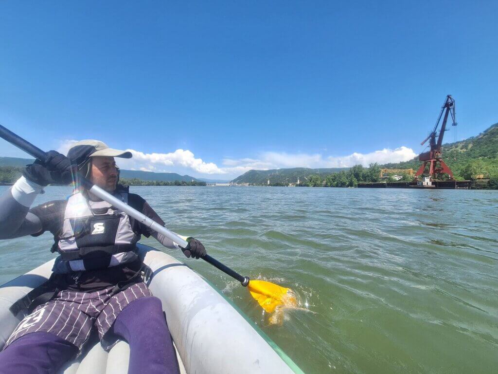 Jonas Breuer kayaking away from Iron Gate I dam Danube River Gura Vaii crane shipping cargo waterway navigation