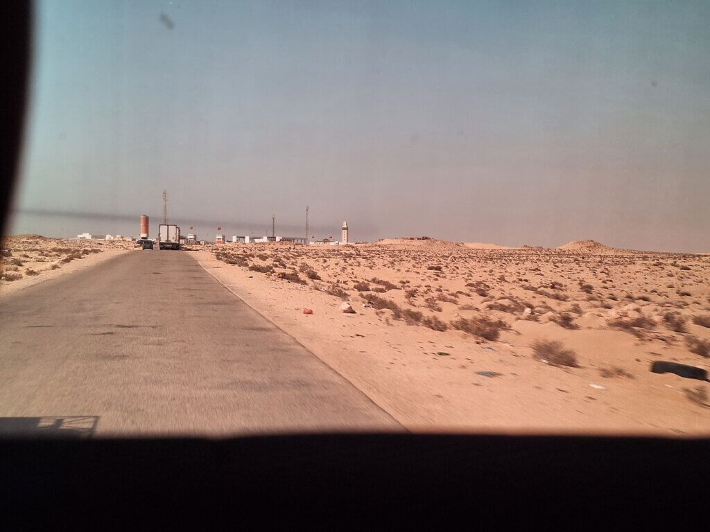 looking back at the Moroccan border from within no man's land the berm western Sahara wall flags occupation