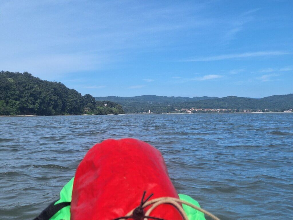 kayaking Danube to Iron Gate II dam looking at Brza Palanka in Serbia from Romania river bend