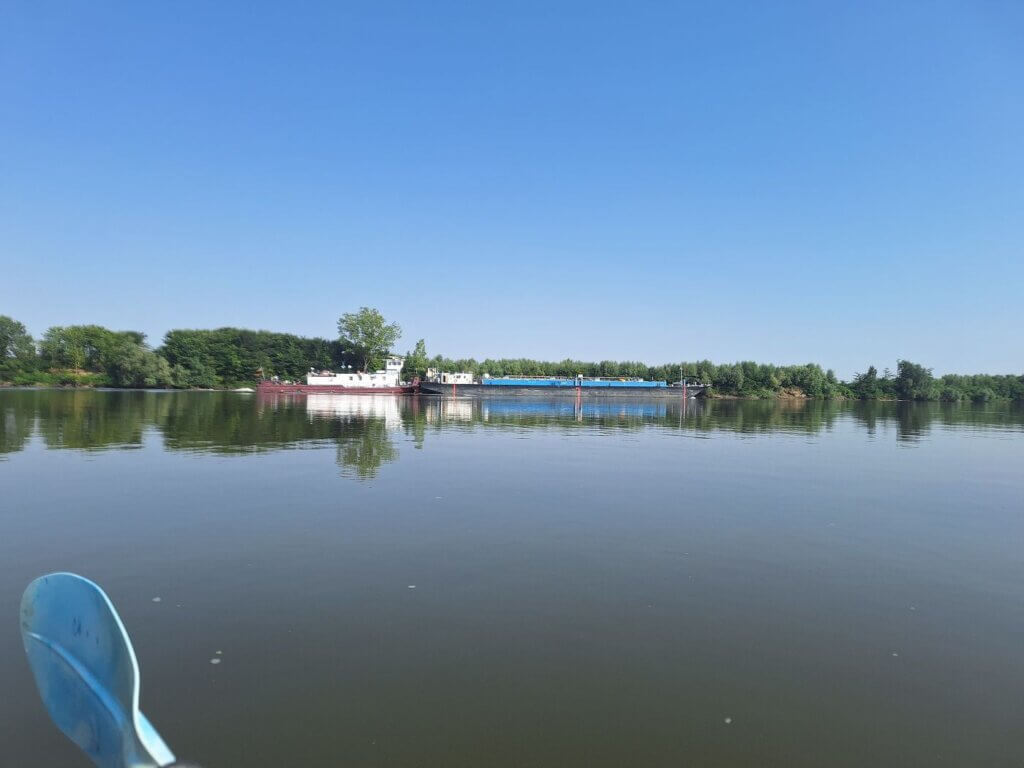 cargo ship overtaking kayak on the lower Danube River Romania near Rasova